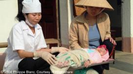 A newborn child is weighed prior to vaccination at Puch Dong CHC (Communal Healt